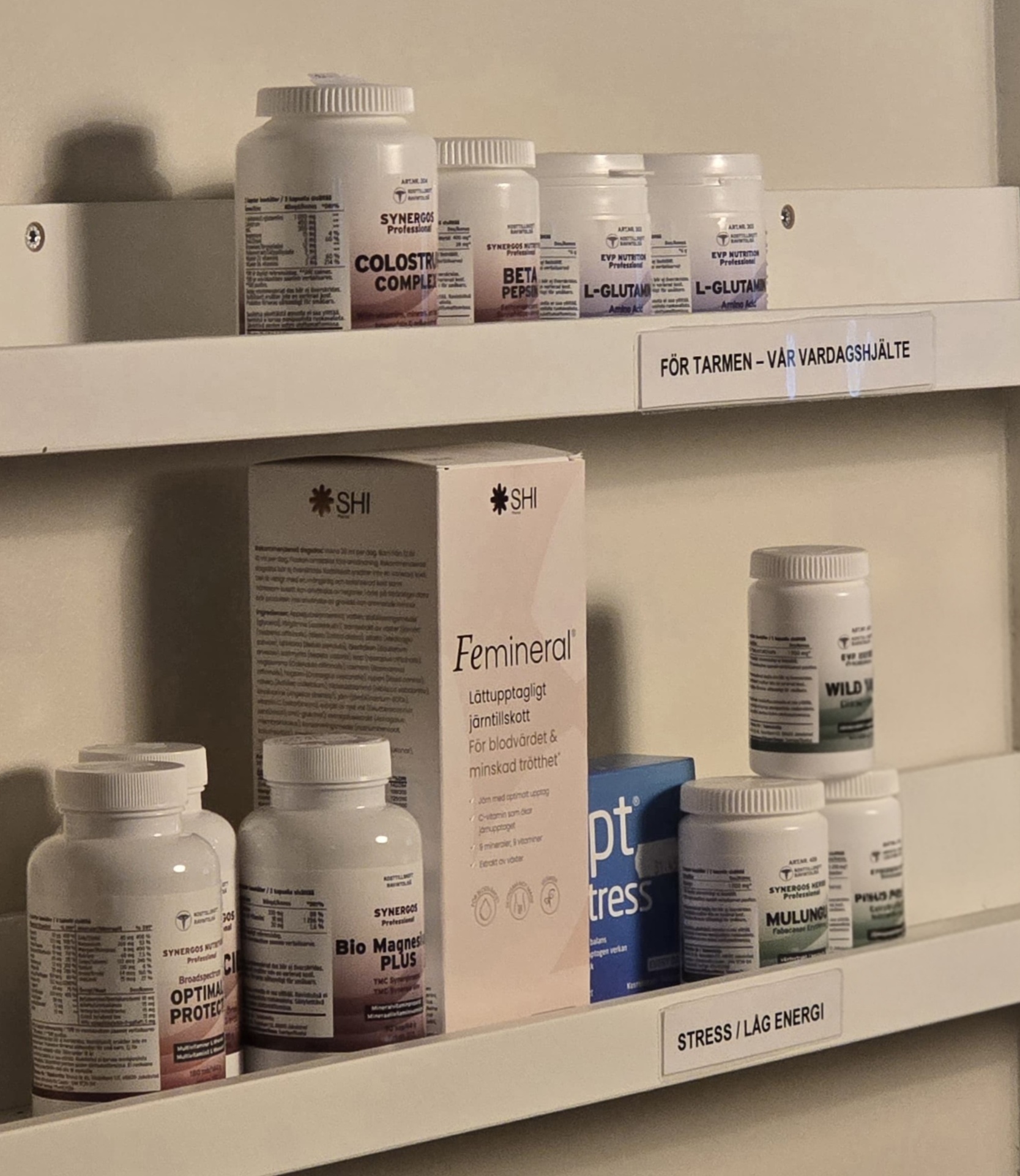 Kosttillskott och vitaminer ordnade på vita hyllor i kliniken